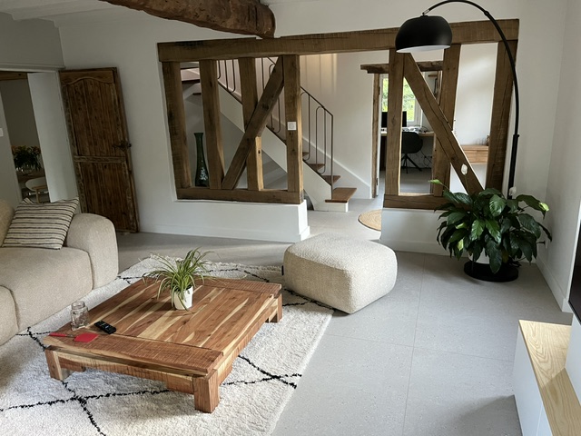 Salon rénové d'une maison ancienne avec colombages et bois clair