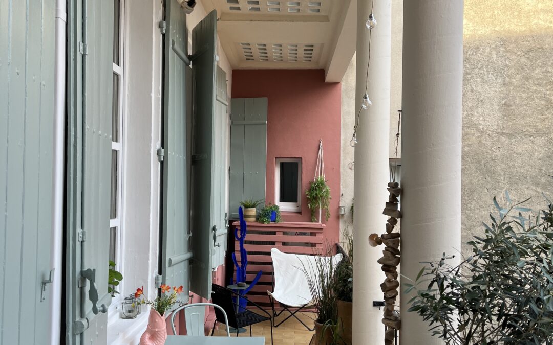 Terrasse aménagée après réalisation avec volets verts mobilier et plantes